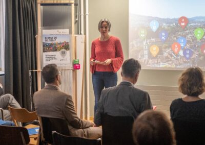 Eva Schmassmann, Plattform Agenda 2030 präsentiert den SDG Walk. Auf Leinwand sieht man das Panorama von Bern mit SDG-Icons verteilt.