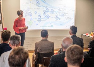 Eva Schmassmann, Plattform Agenda 2030 präsentiert den SDG Walk. Auf Leinwand sieht man die Route und Stationen.