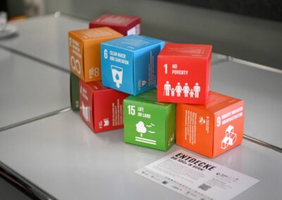 Kleine Papierwürfel mit SDG Icons von SDG 6, 1, 15 und 9