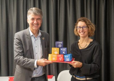 Stadtpräsident Alec von Graffenried und Tatjana von Steiger (Wyss Academy) halten Würfel mit SDG-Icons auf Tablar