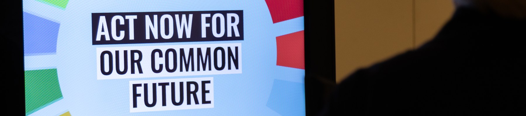 Ein Bildschirm zeigt eine Botschaft: "Act now for our common future"